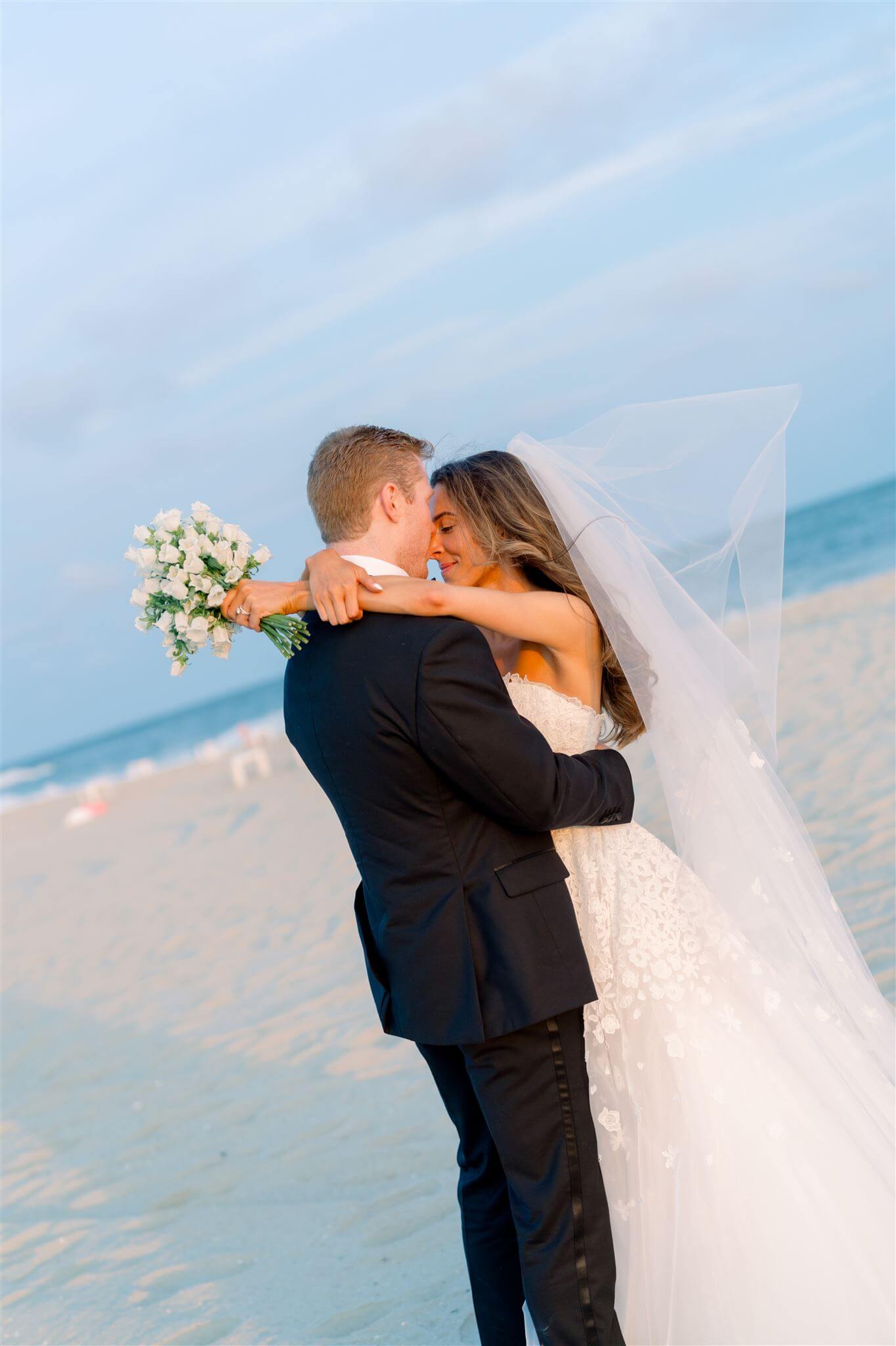 Bride and groom embracing on the beach during their Cape May wedding in New Jersey